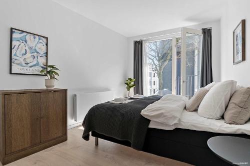 a bedroom with a large bed and a window at Superb First-Floor Mid Town Apartment in Aarhus