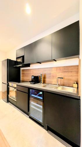 Il comprend une grande cuisine équipée d'un évier et d'une cuisinière. dans l'établissement Le caviste 2ème Étage, à Abbeville