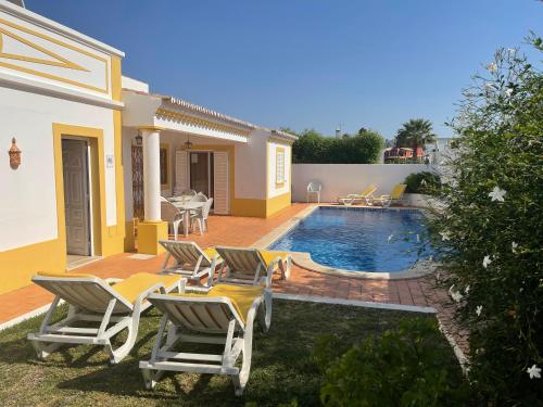 a backyard with chairs and a swimming pool at Villa Ana in Albufeira