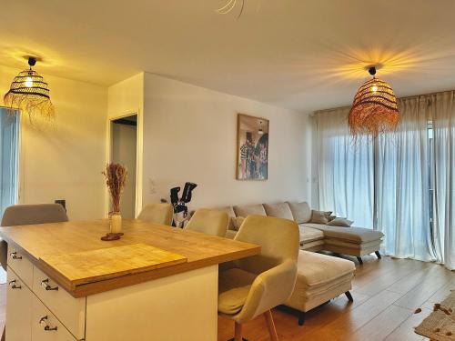 une cuisine et un salon avec une table et un canapé dans l'établissement Appartement plage et lac, à Vieux-Boucau-les-Bains