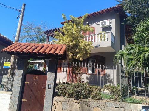 a house with a gate and a fence at suite no centro de miguel pereira in Miguel Pereira