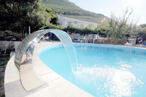 a pool with a water fountain in the middle at Villa Rezevici in Katun