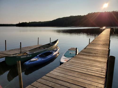 two boats are docked at a dock on a lake at Boulder Lakehouse in Boulder Junction