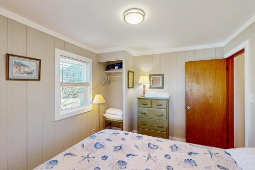a bedroom with a bed and a dresser and a window at Sea View 44 in Avon