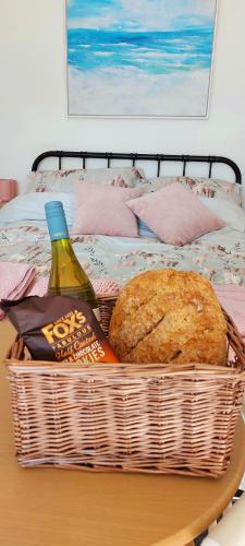 a basket of bread and a bottle of wine on a table at The Snug in Haddenham