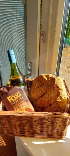a basket with a bottle of wine and bread at The Snug in Haddenham
