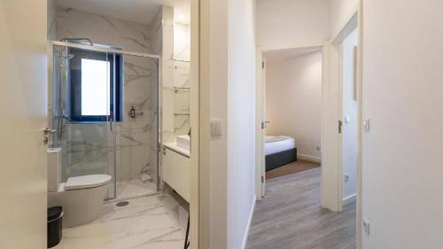 a bathroom with a glass shower and a toilet at Bright 2BR Flat near Praça da Galiza by LovelyStay in Porto