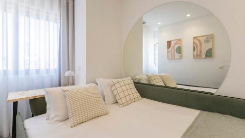 a living room with a mirror and a couch at Bright 2BR Flat near Praça da Galiza by LovelyStay in Porto