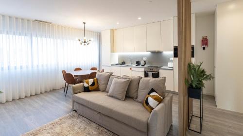 a living room with a couch and a table at Bright 2BR Flat near Praça da Galiza by LovelyStay in Porto