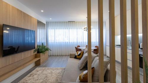 a living room with a tv and a person laying on a chair at Bright 2BR Flat near Praça da Galiza by LovelyStay in Porto