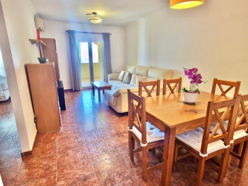 een woonkamer met een houten tafel en stoelen bij Apartamento Milenio Nerja in Nerja
