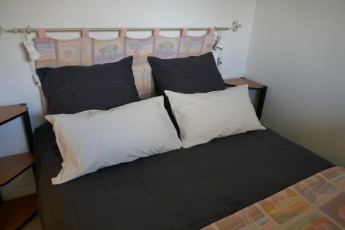 een bed met zwarte en witte kussens erop bij Le Green Set in Pornic