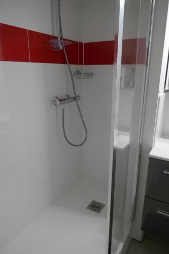een douche in een badkamer met rode en witte muren bij Le Green Set in Pornic