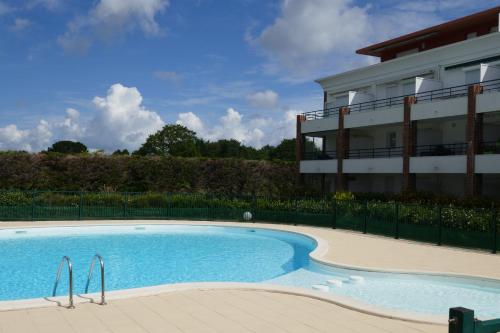 une grande piscine devant un immeuble dans l'établissement Le Green Set, à Pornic