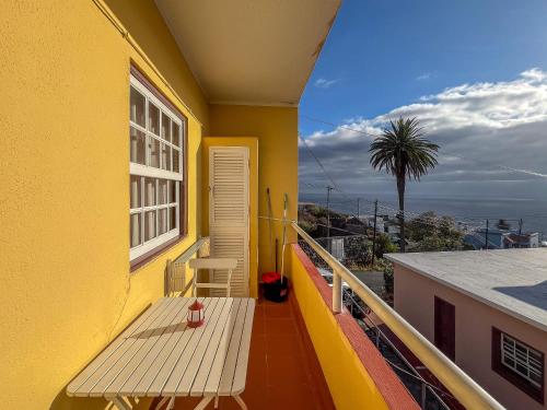 a yellow building with a bench on a balcony at Lightbooking Luymar con piscina Villa de Mazo in Villa de Mazo
