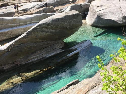 a pool of water with a large boulder in a river at Casa Ai Lupi with Panoramic view in Gordola