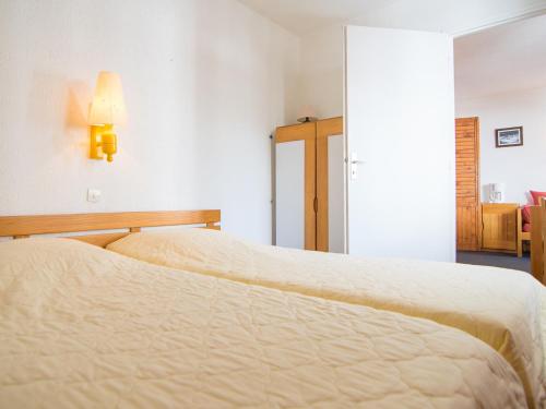 - une chambre avec 2 lits et une lampe sur le mur dans l'établissement Charmant T2 avec Wifi à 500m des pistes - FR-1-449-121, à Tignes