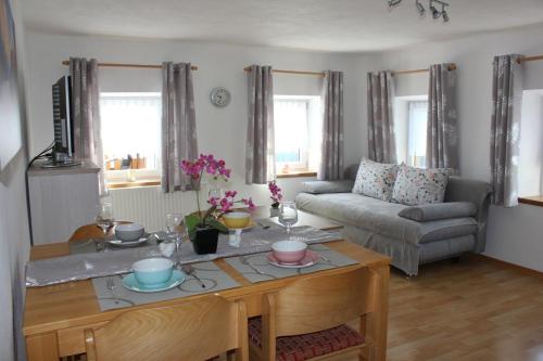a living room with a table and a couch at Ferienwohnungen Esterer in Teisendorf