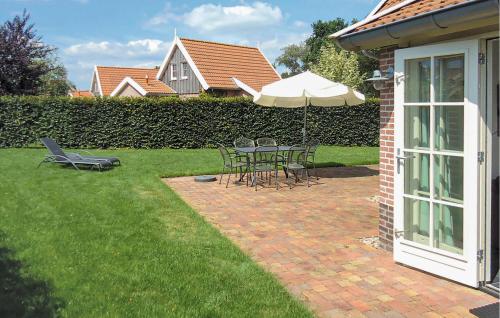 a patio with a table with an umbrella and chairs at Buitengoed Het Lageveld - 133 in Hoge-Hexel