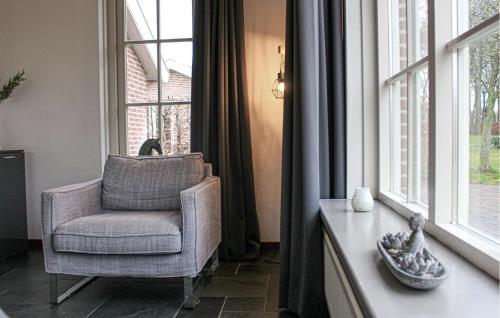 a living room with a chair and a window at Buitengoed Het Lageveld - 133 in Hoge-Hexel