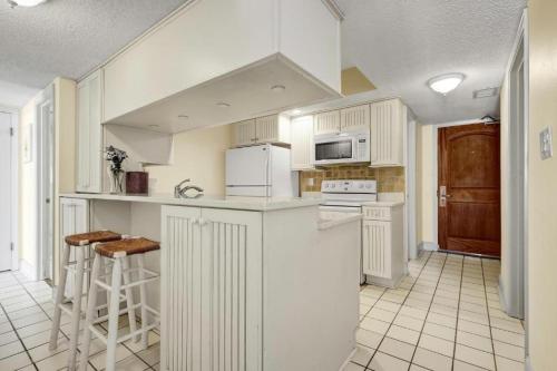 a kitchen with white cabinets and white appliances at Ocean Annie's Resorts in Myrtle Beach