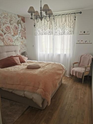 une chambre avec un grand lit et un lustre dans l'établissement Maison tout confort entre terre et mer en Normandie, à Douvres-la-Délivrande