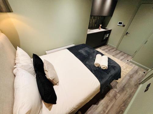 a bedroom with a large bed with white sheets and pillows at Luxury city centre London flats, ideal for tourists in Streatham Vale