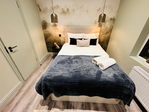 a bedroom with a large bed with a blue blanket at Luxury city centre London flats, ideal for tourists in Streatham Vale