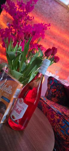 a bottle of sauce next to a vase of flowers at ZAJAZD ALBATROS Rzeszów SPA in Rzeszów