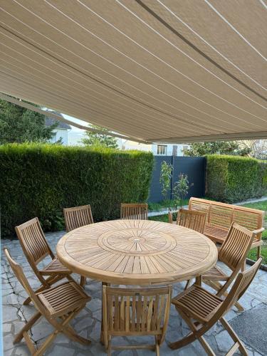 une table et des chaises en bois sous un parasol dans l'établissement Villa in Cosne, à Cosne-Cours-sur-Loire