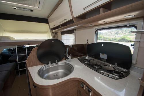 a kitchen with a sink in an rv at Autocaravaning Menorca in Ferreries
