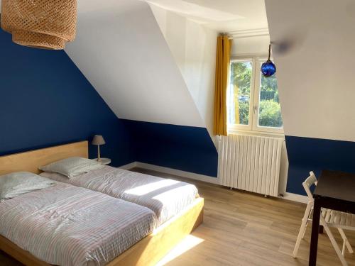 Dormitorio azul y blanco con cama y ventana en Le Logeo 10 couchages, en Sarzeau