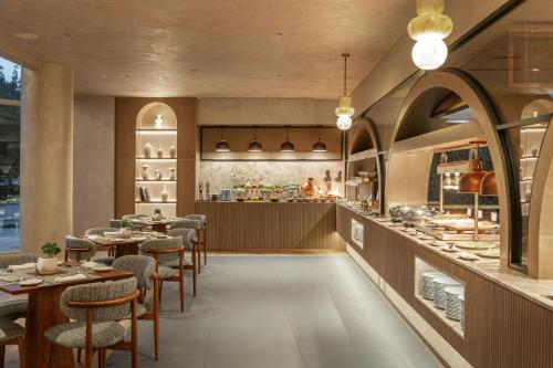 a restaurant with tables and chairs and a bar at Sheraton Jumeirah Beach Resort in Dubai