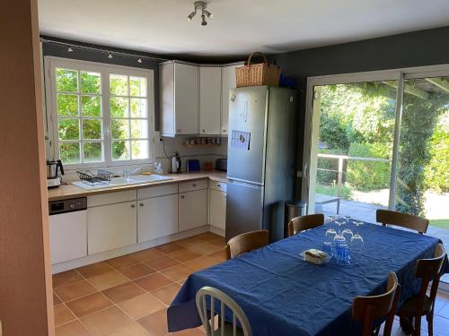 une cuisine avec une table et un réfrigérateur dans l'établissement Le Logeo 10 couchages, à Sarzeau