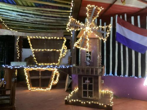 a gingerbread house with christmas lights next to a flag at Vuelo del Águila 4 suites 6 bathrooms alberca in La Esperanza