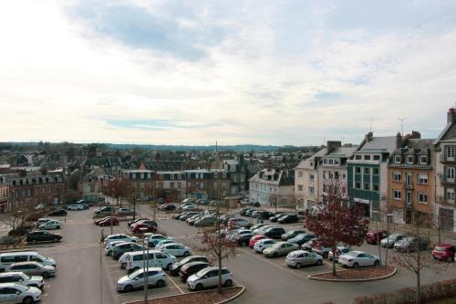 a city with cars parked in a parking lot at Charmant et confortable T2 à Flers in Flers