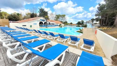 - un groupe de chaises longues bleues et blanches à côté de la piscine dans l'établissement Jolie Mobil home 2 chambres (487), à Saint-Jean-de-Monts