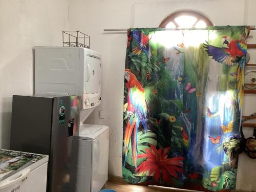 a kitchen with a tropical shower curtain next to a refrigerator at Vuelo del Águila 4 suites 6 bathrooms alberca in La Esperanza