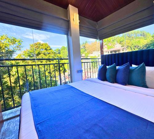 a bedroom with a large bed with a large window at Queens mount in Kandy