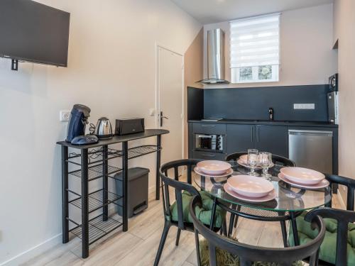 une salle à manger avec une table et des chaises dans une cuisine dans l'établissement Studio centre ville La Bourboule, à La Bourboule