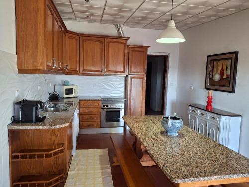 a kitchen with wooden cabinets and a counter top at Casa da Corte in Mina de São Domingos