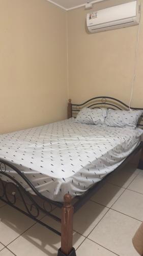 an empty bed in a room with a fan at the hideaway in Christ Church