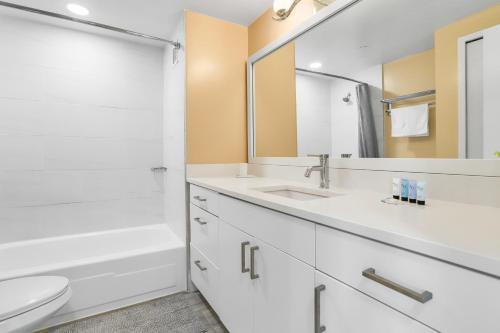 a bathroom with a sink and a toilet and a mirror at Stylish Apt in Crystal City in Arlington
