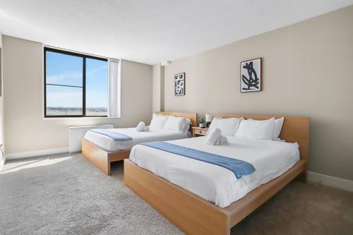 a bedroom with two beds and a large window at Stylish Apt in Crystal City in Arlington