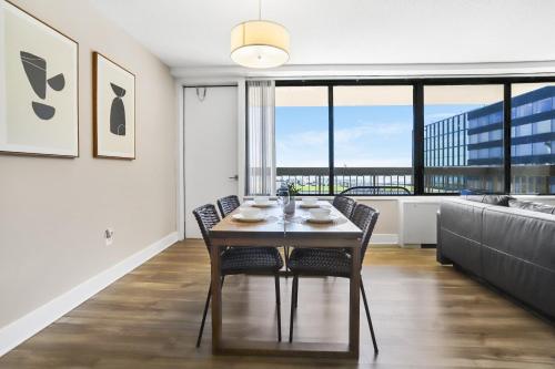 a dining room with a table and chairs and a large window at Stylish Apt in Crystal City in Arlington
