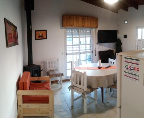 a dining room with a table and chairs and a fireplace at La casa de Yoni in Las Toninas