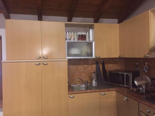 a kitchen with wooden cabinets and a microwave at CA' BELLAVISTA in Bardolino