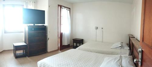 杜伊塔马Hotel Esmeralda Duitama的一间卧室，配有两张床和一台平板电视