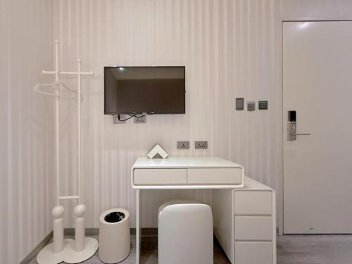 a bathroom with a sink and a tv on the wall at 在家行旅 南西館 in Taipei