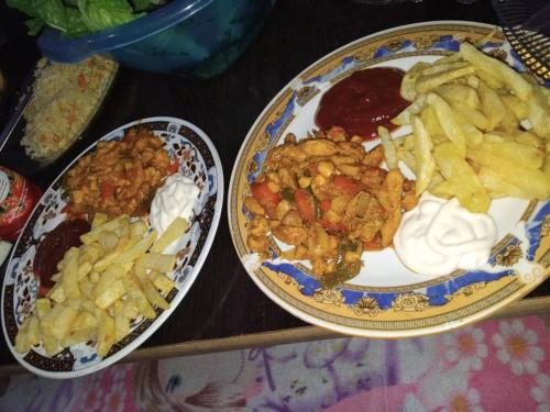 two plates of food and french fries on a table at Hggh in Antipolo